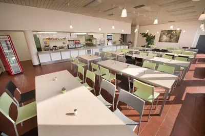 a restaurant with tables and chairs and a cafeteria at Hotel Energie in Prague