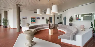 a waiting room with couches and plants in a building at Hotel Energie in Prague
