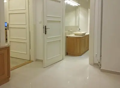 a bathroom with a white door and a sink at New apartment in a historical building in Prague