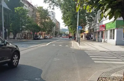 an empty city street with a car driving down the street at New apartment in a historical building in Prague