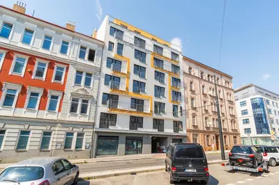 a large white building with cars parked in front of it at Brand new studio apartment # 42 in brand new building with free parking in the center in Prague