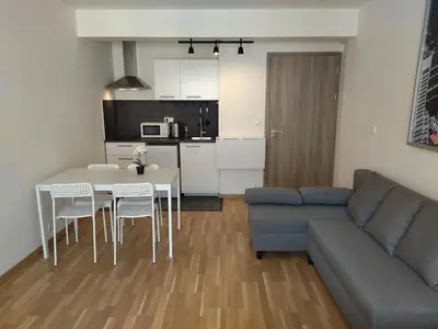 a living room with a couch and a table and chairs at Brand new studio apartment # 42 in brand new building with free parking in the center in Prague