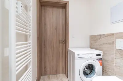 a laundry room with a washer and dryer at Brand new studio apartment # 42 in brand new building with free parking in the center in Prague