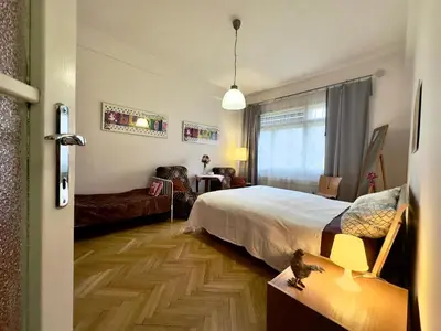 a bedroom with a bed and a living room at Apartment Sedlčanská - You Will Save Money Here - equipped with antique furniture in Prague