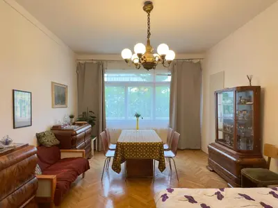 a living room with a table and a chandelier at Apartment Sedlčanská - You Will Save Money Here - equipped with antique furniture in Prague