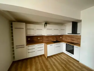 an empty kitchen with white cabinets and wooden floors at Apartment Spa and Fontain Poděbrady in Poděbrady