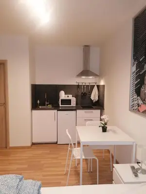 a kitchen with a white table and white chairs at Studio brand new apartment #28 in new building with free parking in city center in Prague