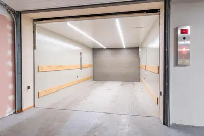 an empty room with a garage door in a building at Studio brand new apartment #28 in new building with free parking in city center in Prague