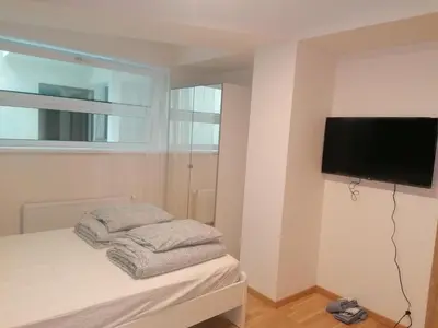 a bedroom with a flat screen tv on a wall at Studio brand new apartment #28 in new building with free parking in city center in Prague