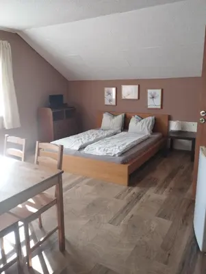 a bedroom with a bed and a table in it at Apartmány Audy in Mníšek pod Brdy