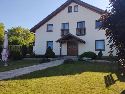 a white house with an umbrella in the yard at Apartmány Audy in Mníšek pod Brdy
