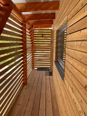a wooden corridor in a log cabin with a window at Apartmán - F - Vyhlídka nad řekou in Zdiby