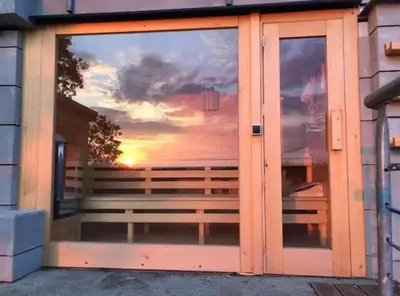a glass door with a reflection of a sunset at Apartmán - F - Vyhlídka nad řekou in Zdiby