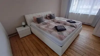a bedroom with a white bed with pillows on it at Apartmán Na Polabí 2 in Mělník