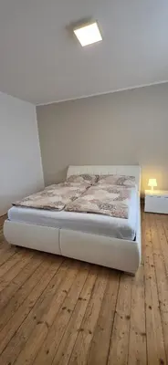 a bed in a room with a wooden floor at Apartmán Na Polabí 2 in Mělník