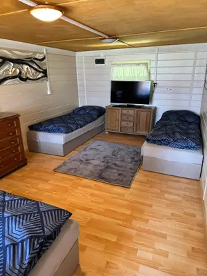 a room with two beds and a flat screen tv at Chata U Řeky in Volenice