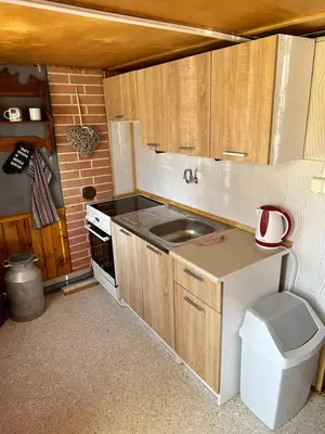 a small kitchen with a sink and a stove at Chata U Řeky in Volenice