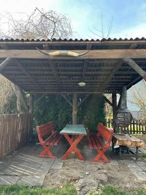 a picnic table and two chairs under a gazebo at Chata U Řeky in Volenice