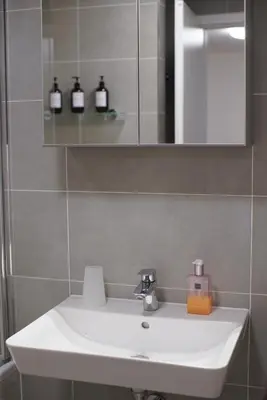 a bathroom with a white sink and a mirror at Holešovice Delight: Modern Comfort with a Twist in Prague 7 in Prague