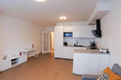 an open kitchen and living room with white cabinets at Holešovice Delight: Modern Comfort with a Twist in Prague 7 in Prague