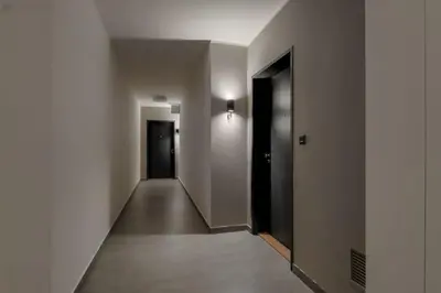 an empty hallway with white walls and a black door at Holešovice Delight: Modern Comfort with a Twist in Prague 7 in Prague