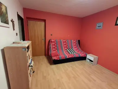a bedroom with a bed with a red wall at Pokoj v rodinném se sdílenou koupelnou in Černošice