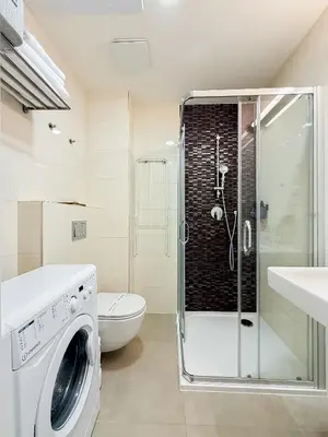 a bathroom with a shower and a washing machine at TurnKey I National Museum Apartments in Prague