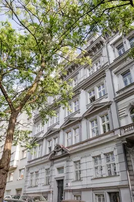 a white building with a tree in front of it at TurnKey I National Museum Apartments in Prague