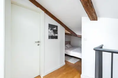 a bedroom with a white bed and wooden ceilings at Duplex apartment with AC in Prague Center in Prague