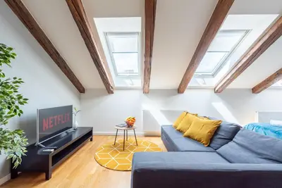 a living room with a blue couch and a tv at Duplex apartment with AC in Prague Center in Prague