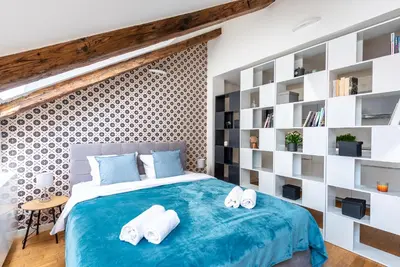 a bedroom with a blue bed with white pillows at Duplex apartment with AC in Prague Center in Prague