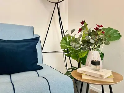 a living room with a blue couch and a white table at Beautiful New Town Apartment in Prague