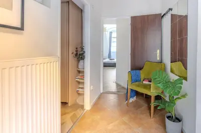a hallway with a green chair and a plant at Beautiful New Town Apartment in Prague