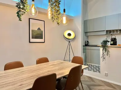 a dining room with a wooden table and a kitchen at Beautiful New Town Apartment in Prague