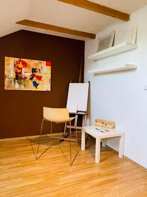 a room with a chair and a table and a painting at Letní dům Ždáň in Slapy