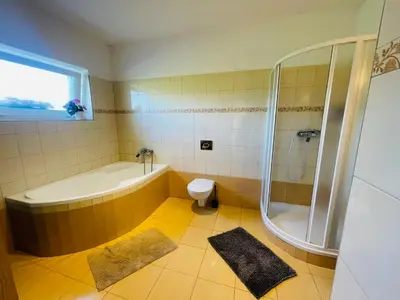 a bathroom with a tub and a shower and a toilet at Letní dům Ždáň in Slapy