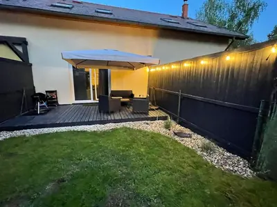a backyard with a wooden fence and an umbrella at Letní dům Ždáň in Slapy
