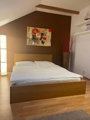 a bedroom with a large bed with a wooden headboard at Letní dům Ždáň in Slapy