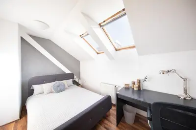 a small bedroom with a bed and a desk at Bohéme Apartment Prague Three in Prague