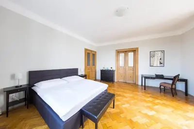 a bedroom with a large bed and a desk at Bohéme Apartment Prague Three in Prague