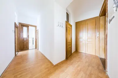 an empty hallway with white walls and wooden doors at Bohéme Apartment Prague Three in Prague