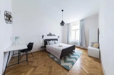 a bedroom with a bed and a desk and a table at Bohéme Apartment Prague Three in Prague