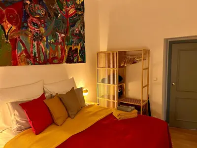 a bedroom with a bed with red and yellow pillows at Green balcony & king size bed in Prague
