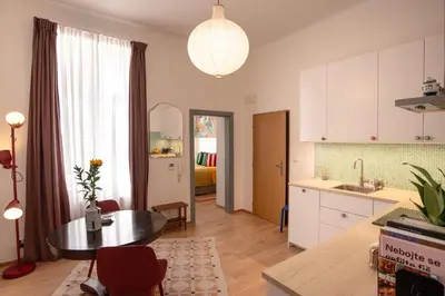 a kitchen and living room with a table and a dining room at Green balcony & king size bed in Prague
