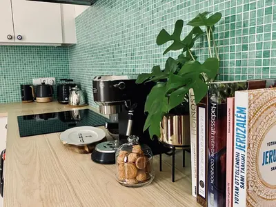 a kitchen counter with a coffee maker and books at Green balcony & king size bed in Prague