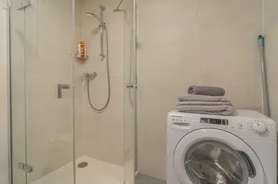 a bathroom with a washing machine and a shower at Apartment Karel with garage parking in Prague