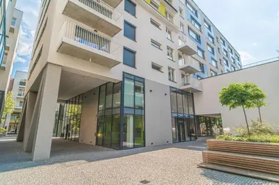 a large building with glass windows and a tree at Apartment Karel with garage parking in Prague