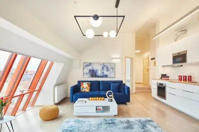 a living room with a blue couch and a table at Karlova Old Town Apartments in Prague