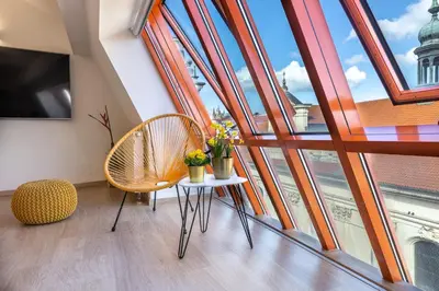 a room with a table and chairs and windows at Karlova Old Town Apartments in Prague