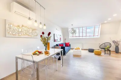 a white living room with a table and chairs at Karlova Old Town Apartments in Prague